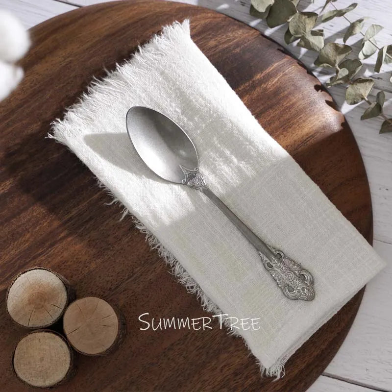 Silver spoon on a white napkin with wooden elements and 'SUMMER TREE' branding.