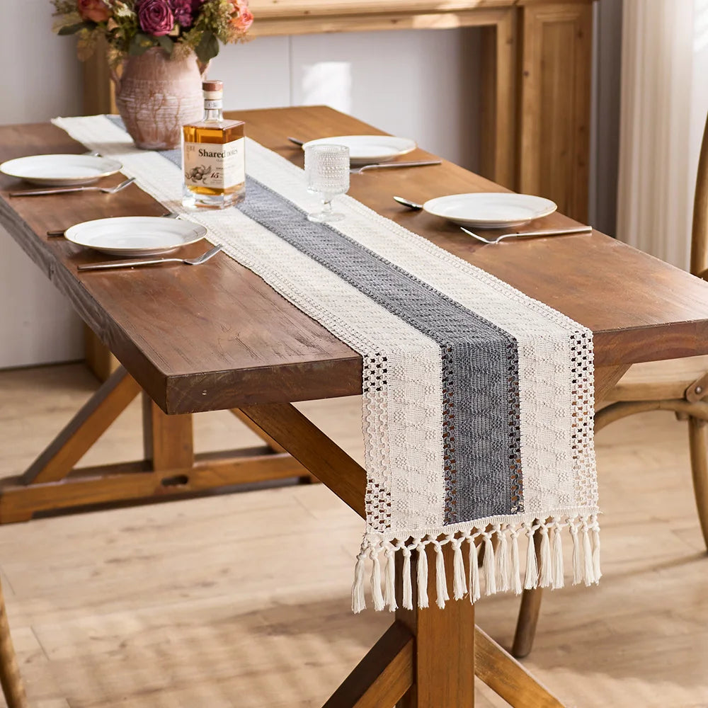 Dining table set with a decorative table runner, plates, and cutlery in a home setting.