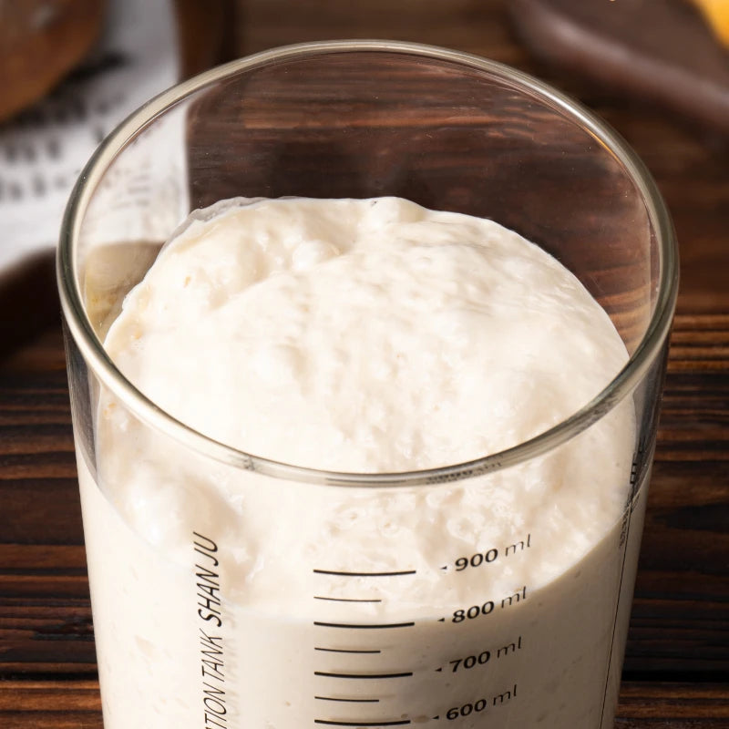 Glass measuring cup filled with a white substance on a wooden surface
