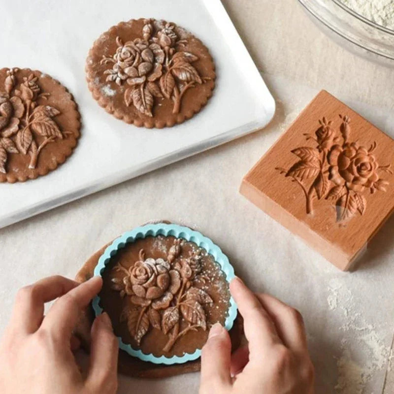 Decorative cookie stamps with floral designs on cookies and a stamp block.