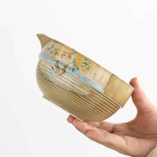 Hand holding a decorative book with floral illustrations on a white background