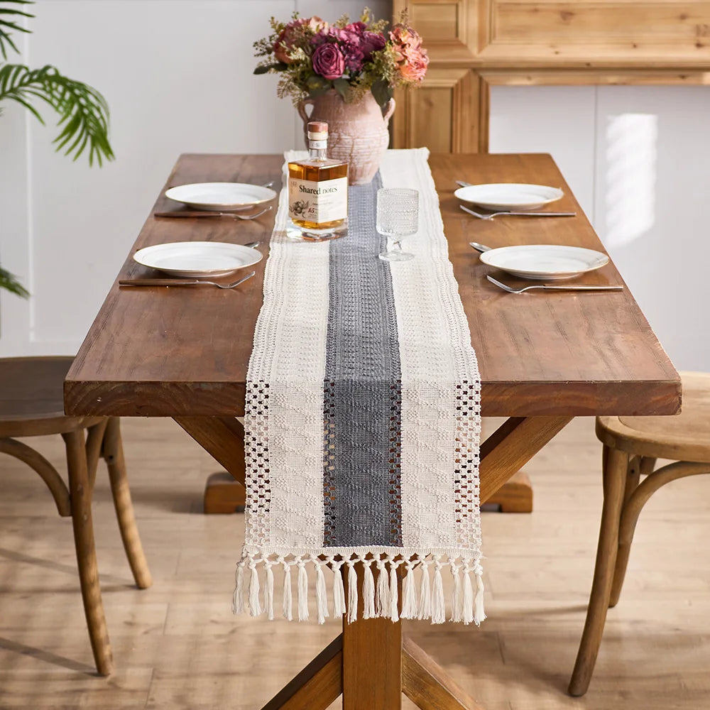 Dining table set with a checkered table runner, plates, and glasses in a home setting.