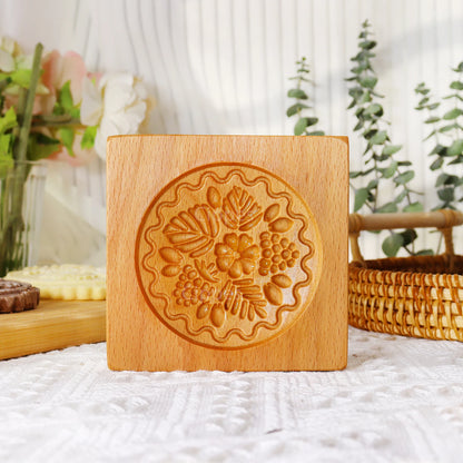 Wooden stamp with floral design on a white surface with plants in the background