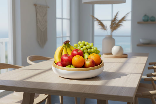 Fruit bowl with bananas, apples, oranges, and grapes on a white background