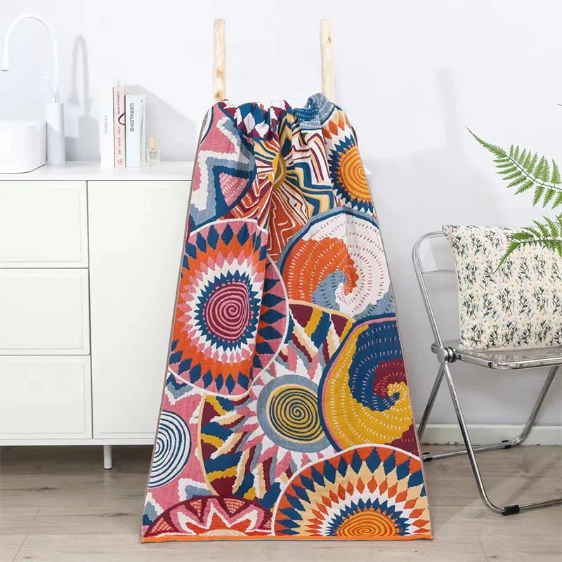 Colorful patterned towel hanging on a rack with a white cabinet and chair in the background.