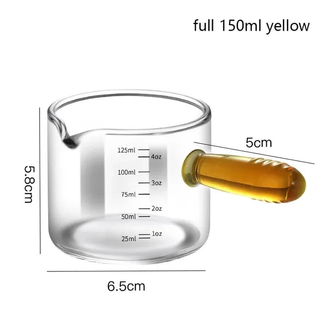 Glass measuring cup with liquid and measurements labeled on a white background