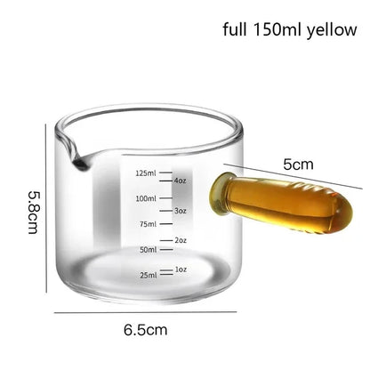 Glass measuring cup with liquid and measurements labeled on a white background