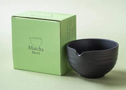 Black matcha bowl next to a green box labeled 'Matcha Bowl' on a light green background