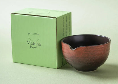 Ceramic matcha bowl next to its packaging box on a light green background