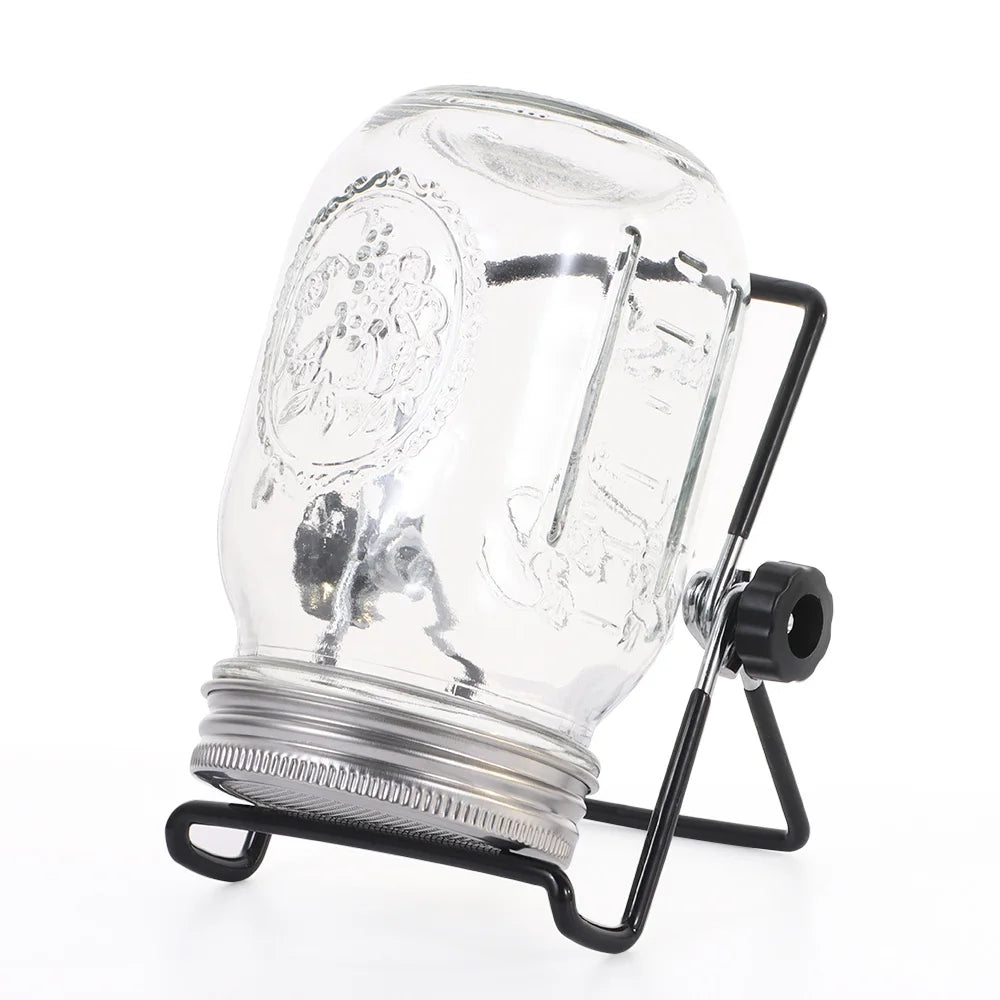 Clear glass mason jar with black metal stand on a white background