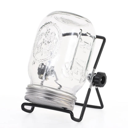 Clear glass mason jar with black metal stand on a white background