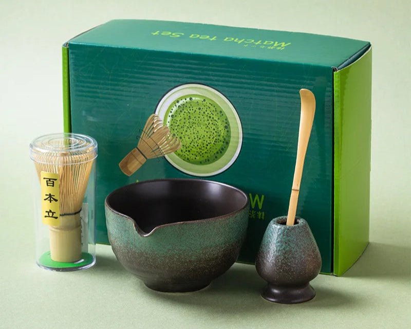 Matcha tea set with bowl, whisk, and holder in front of a green box on a light green background