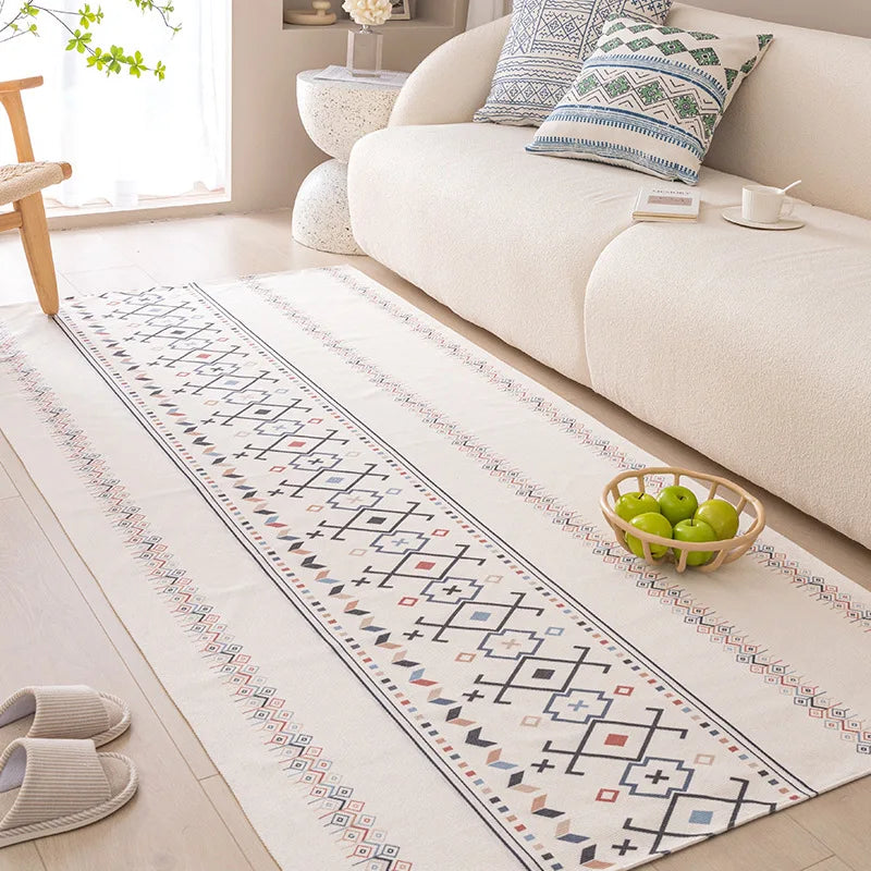 Long decorative rug with geometric pattern on a light wooden floor in a living room.