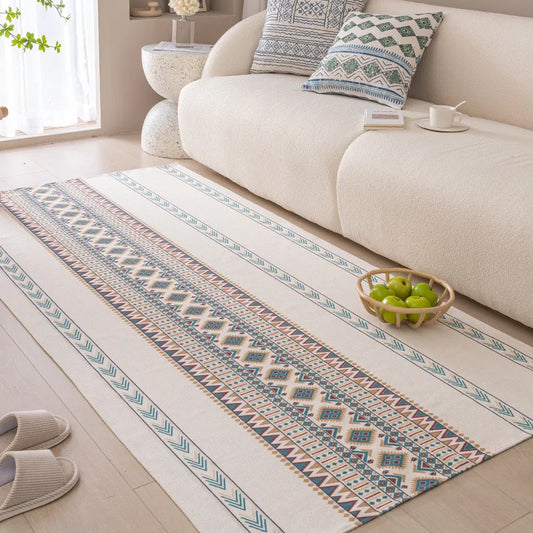Patterned rug on a wooden floor in a living room with a sofa and decorative items.