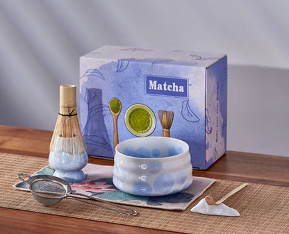 Matcha tea set with bowl, whisk, and box on a wooden surface