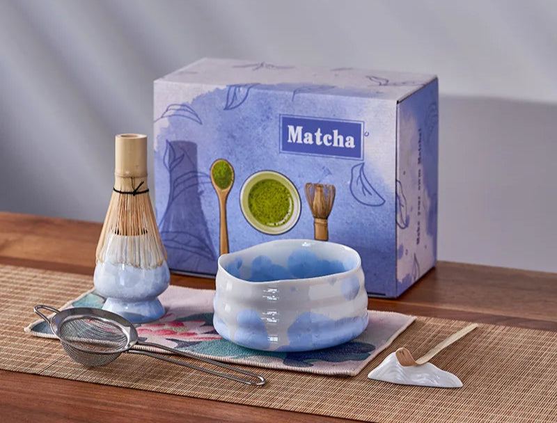 Matcha tea set with bowl, whisk, and box on a wooden surface