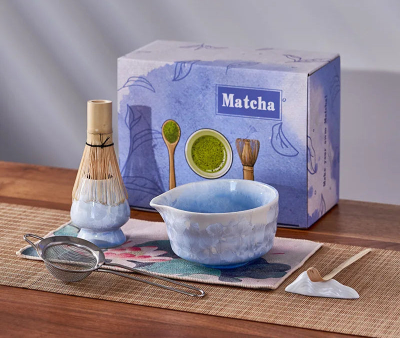 Matcha tea set with bowl, whisk, and box on a wooden surface