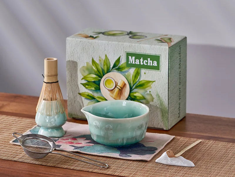 Matcha tea set with bowl, whisk, and box on a wooden surface