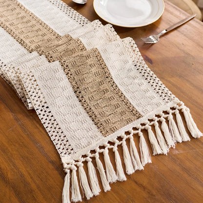Decorative table runner with lace patterns and tassels on a wooden table.