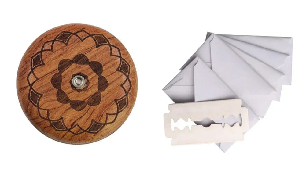 Wooden button with floral design and a white razor on a white background