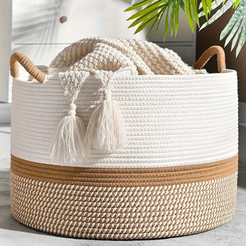 White and beige woven basket with tassels on a light surface.