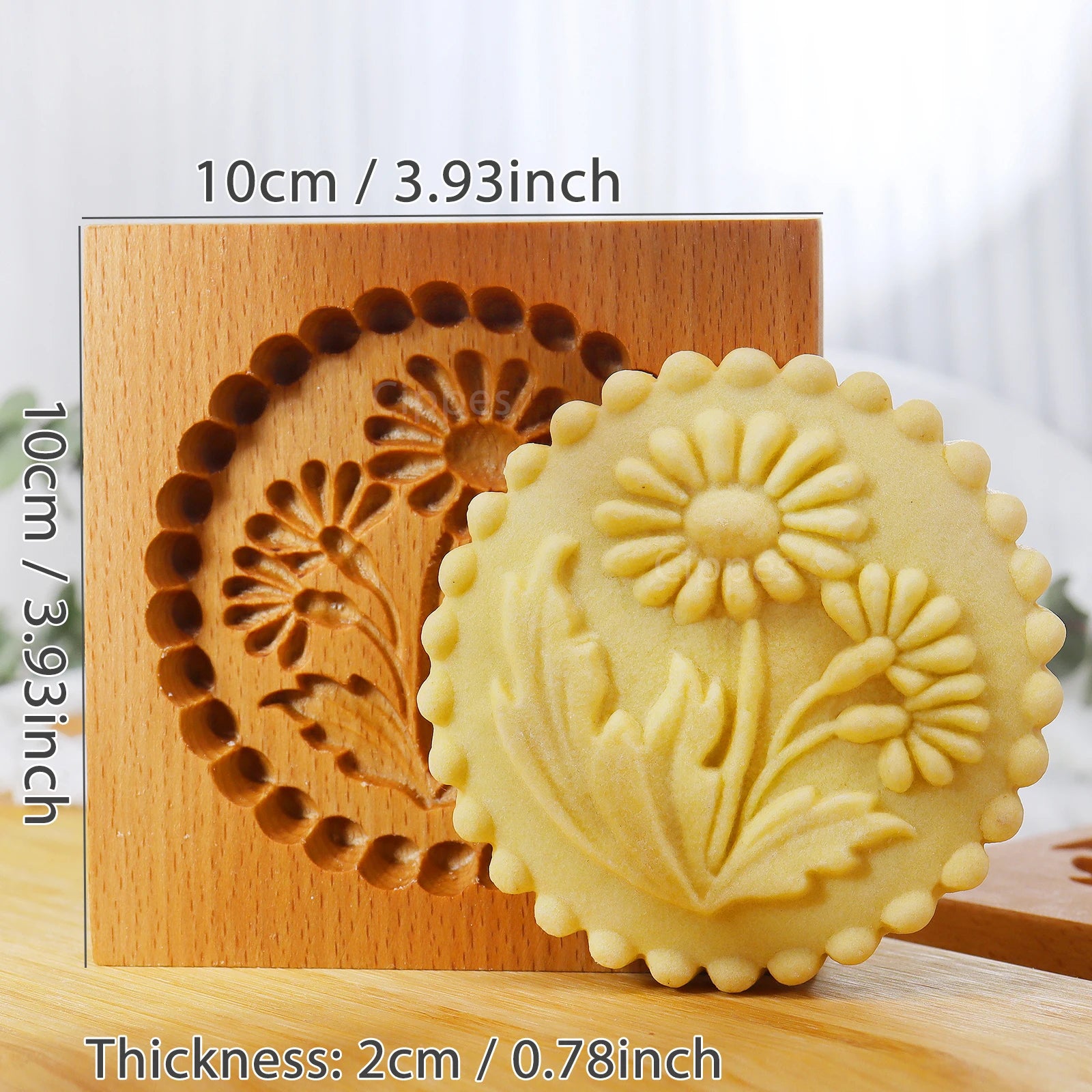 Wooden cookie stamp with floral design and a cookie featuring the same design on a light background.