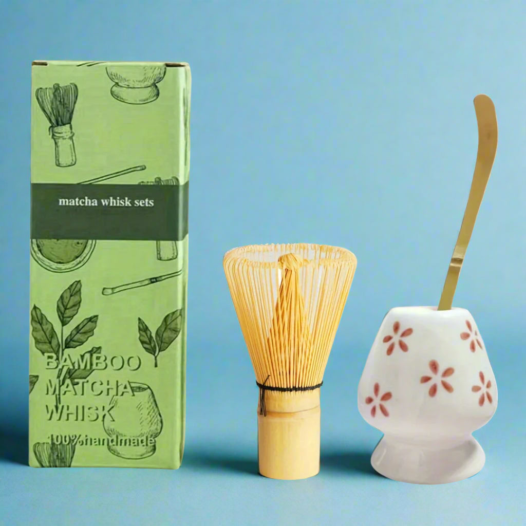 Bamboo matcha whisk set with green packaging and ceramic holder on a white background