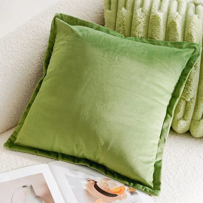 Green pillow on a couch next to a blanket
