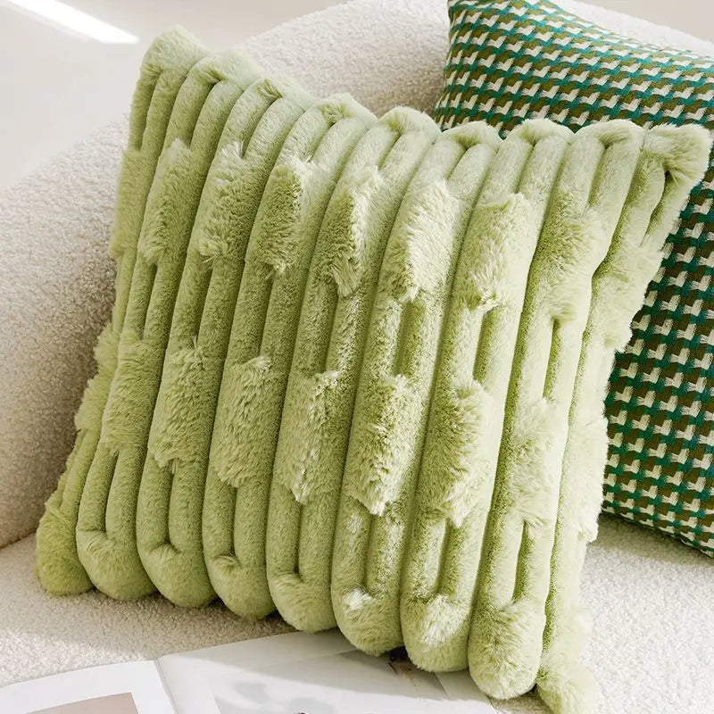 Green textured pillow on a couch with a patterned pillow in the background