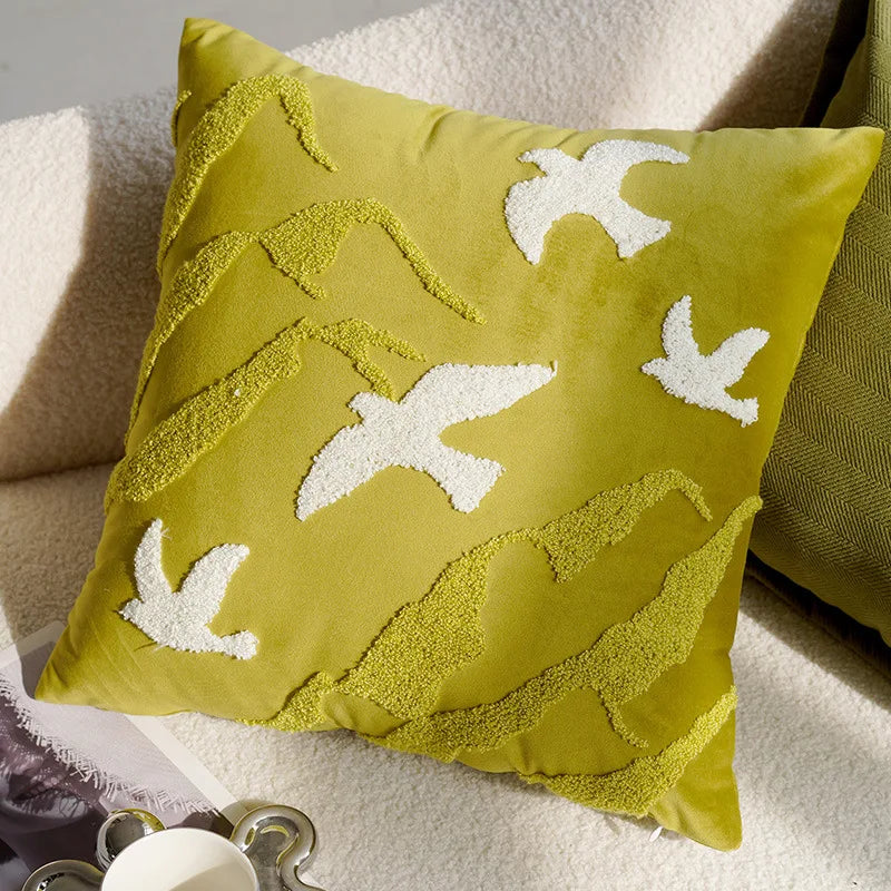 Yellow pillow with white leaf patterns on a soft surface