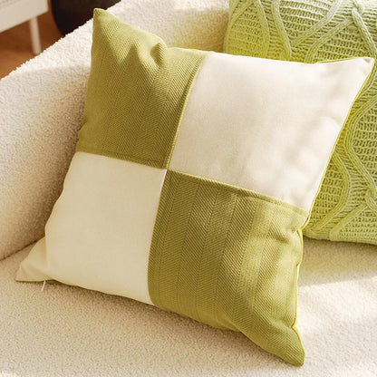 Green and white patchwork pillow on a beige sofa
