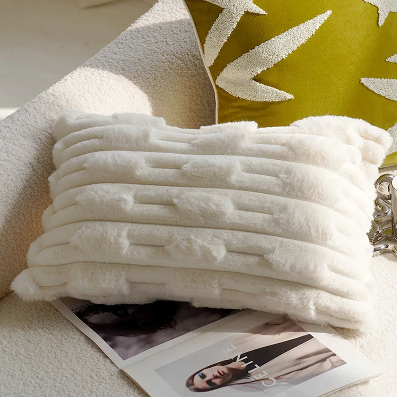 Stack of white towels on a surface with a green decorative pillow in the background