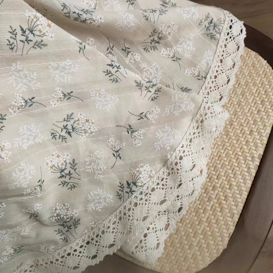 Floral-patterned fabric with lace edge on a wooden surface