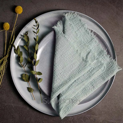 Light green napkin on a gray plate with decorative elements on a dark surface