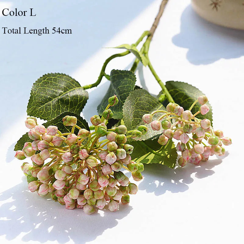 Artificial flower branch with pink and green buds on a light background