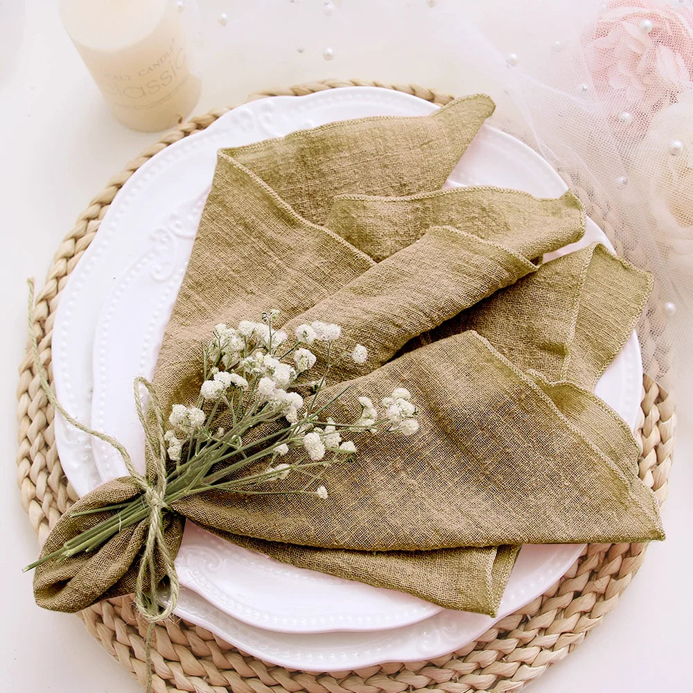 Green folded napkin with baby's breath on a white plate with a woven placemat.