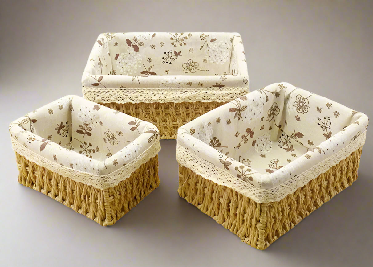 Three woven baskets with floral fabric lining on a white background