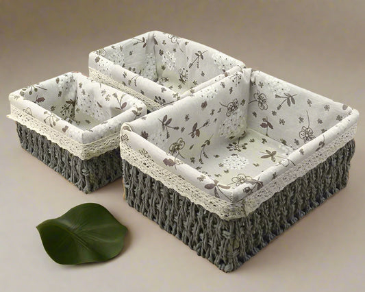 Set of three woven baskets with floral fabric lining on a white background