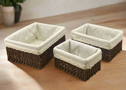 Three square storage baskets with wicker exterior and beige fabric interior on a white background.