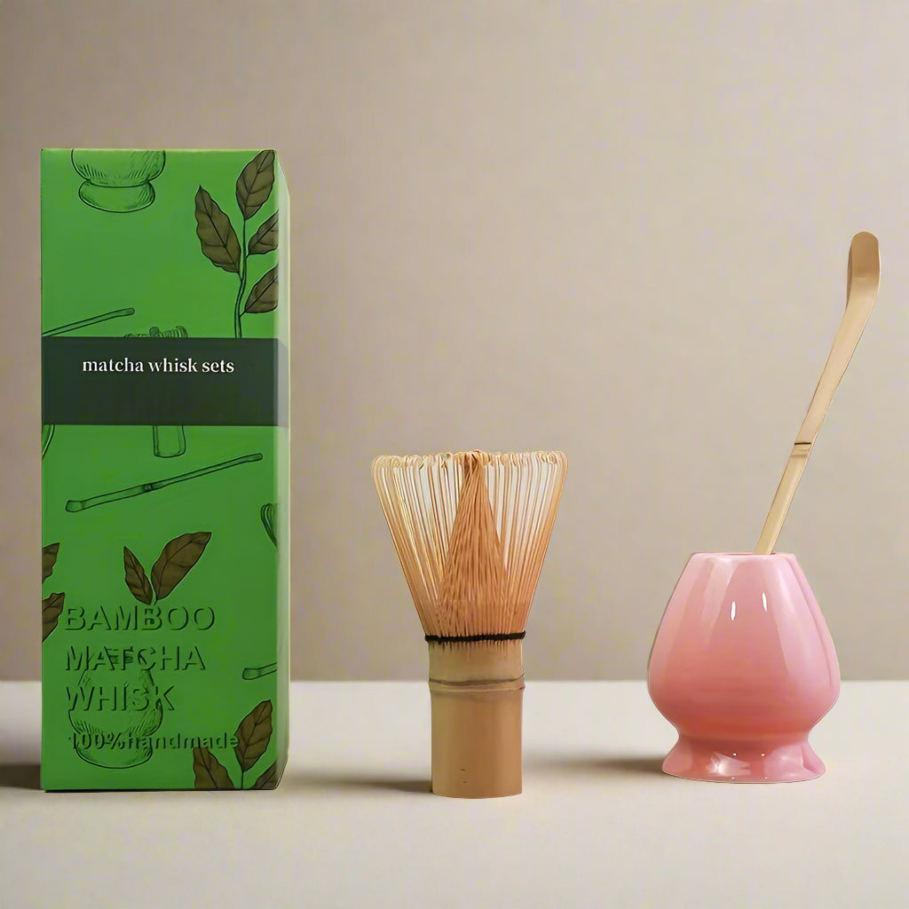 Bamboo matcha whisk set with pink holder and green packaging on a white background