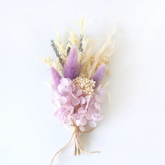 Bouquet of dried flowers with lavender, pink hydrangeas, and beige branches on a white background