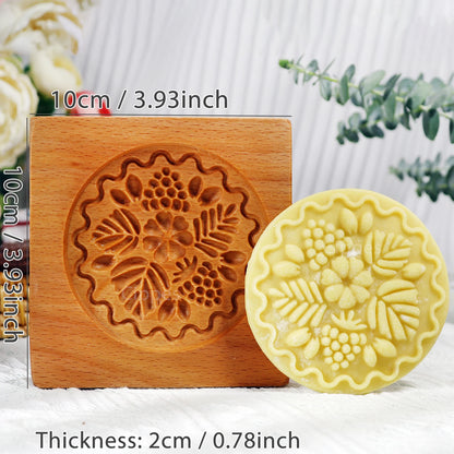 Wooden mold with floral design and a yellow soap bar next to it, showing measurements.
