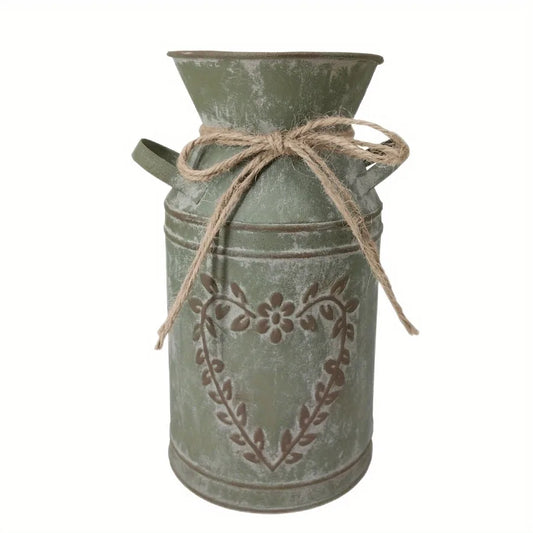 Decorative metal milk churn with floral design and twine on a white background