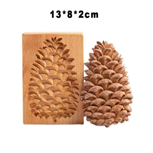 Wooden pineapple mold next to a real pinecone on a white background