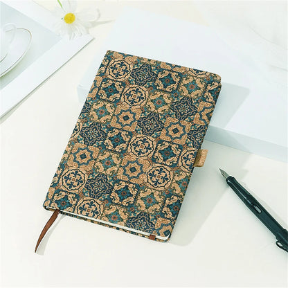 Decorative notebook with a pattern on a white surface with a pen next to it