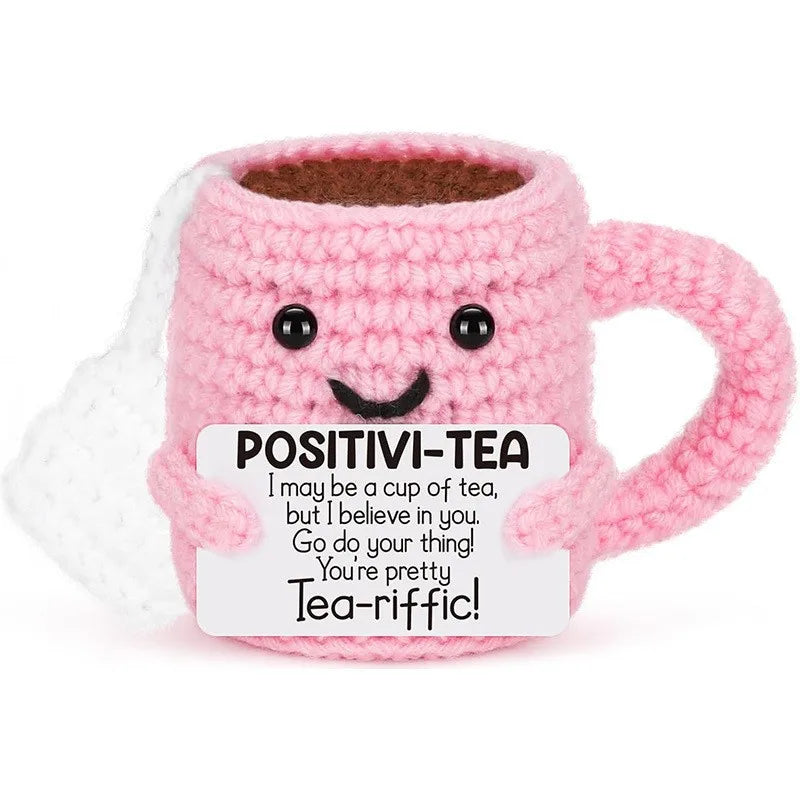 Pink crochet mug with a smiling face and text on a white background