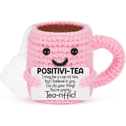 Pink crochet mug with a smiling face and text on a white background