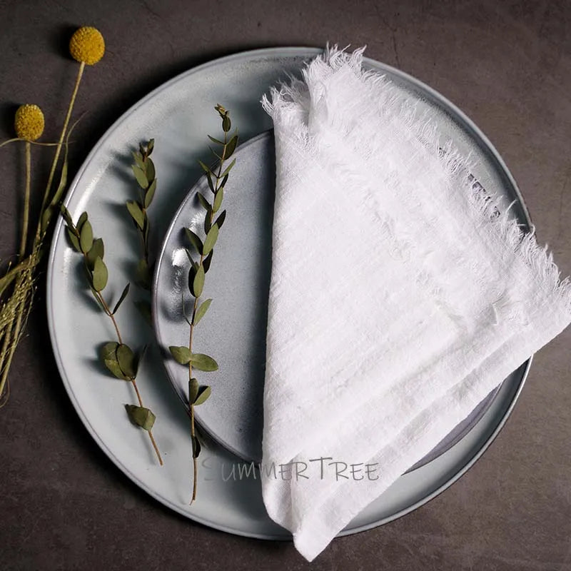 White napkin on a gray plate with greenery and a yellow flower, branded 'SUMMER TREE'.