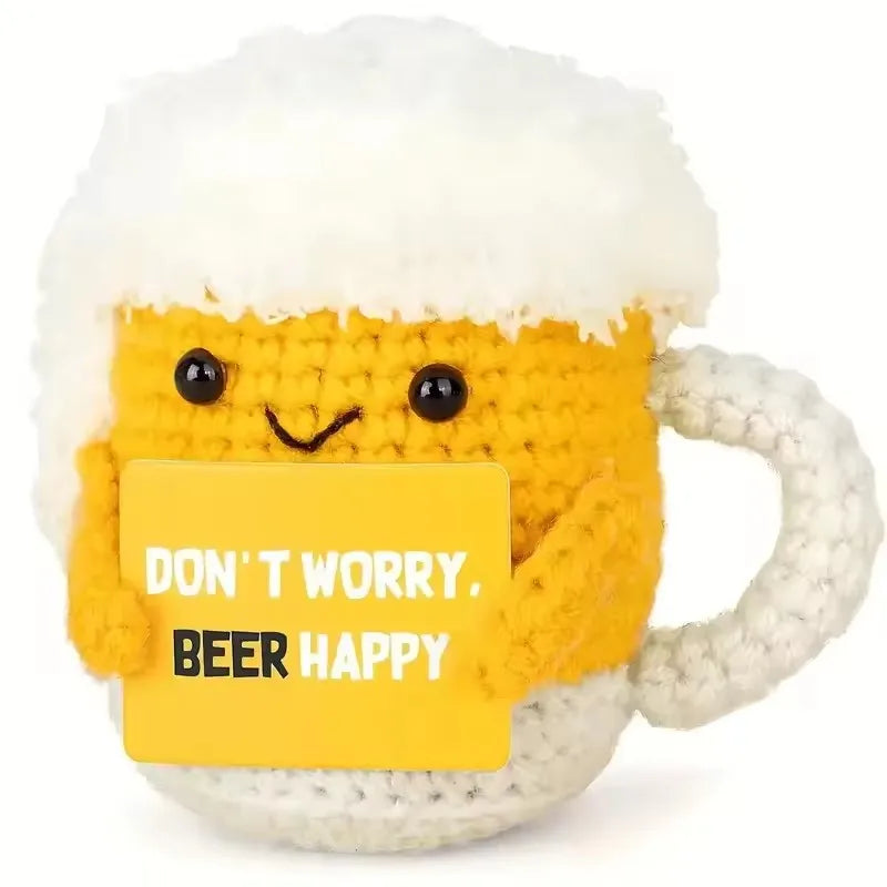Crocheted beer mug with a face and 'Don't worry, beer happy' sign on a white background