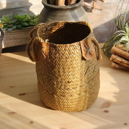 Woven basket with leather straps on a wooden surface